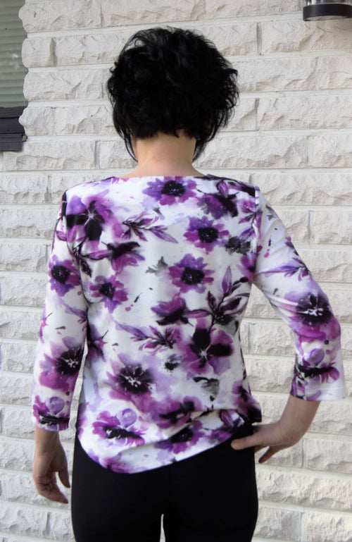 Modelian paita valkoisella pohjalla jossa lilan värinen kukkakuvio 